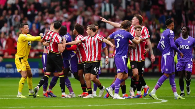 Players come together in a melee after full-time