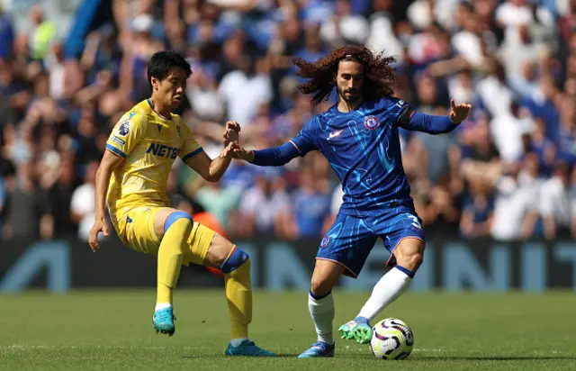 Marc Cucurella of Chelsea controls the ball under pressure from Daichi Kamada