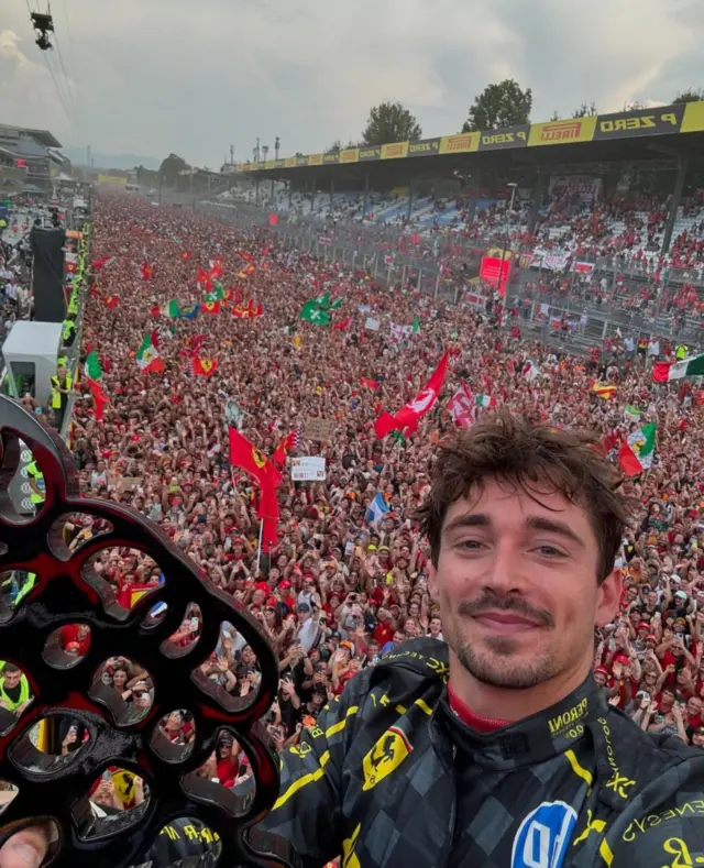 Charles Leclerc takes a selfie on the podium