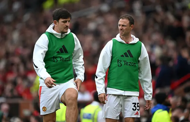 Harry Maguire and Jonny Evans of Manchester United interact