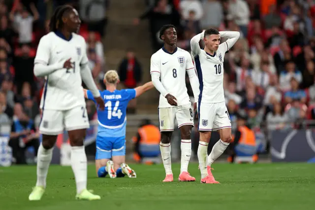 Kobbie Mainoo and Phil Foden of England react