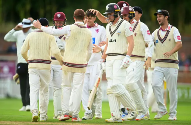 Archie Vaughan celebrates the wicket of Ben Geddes with Somerset team-mates