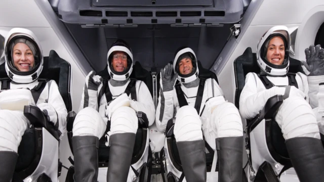 Left to right: Anna Menon, Scott Poteet, Jared Isaacman and Sarah Gillis seated in rocket in white and black space suits