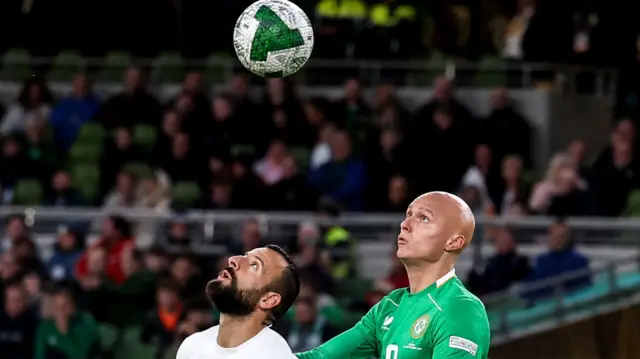 Greece's Manolis Siopis and Will Smallbone contest a high ball in the Nations League game