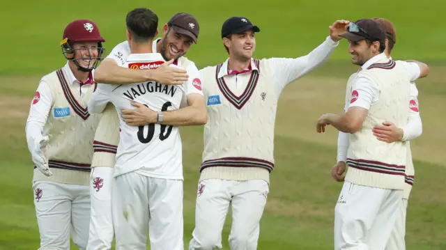 Archie Vaughan of Somerset CC celebrates taking the wicket of Dominic Sibley