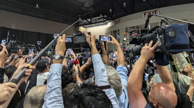 Reporters crowd around Donald Trump