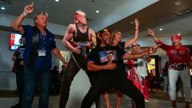 Supporters of former President Trump with a cardboard cut-out of him at a watch party in Florida