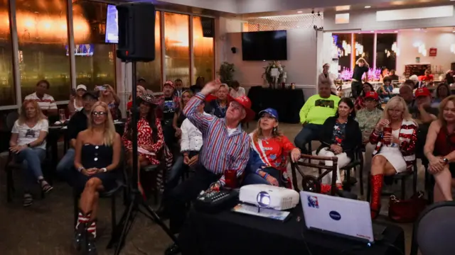 A viewer throws a Nerf ball at a TV during a Republican presidential debate watch party in Lake Worth, Florida