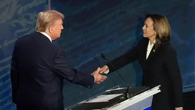 Republican presidential candidate Donald J. Trump (L) and Democratic presidential candidate US Vice President Kamala Harris shake hands at the start of a presidential debate