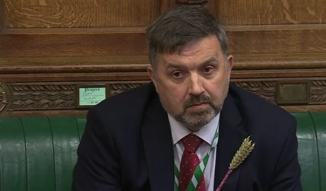 Man in suit sitting in commons.