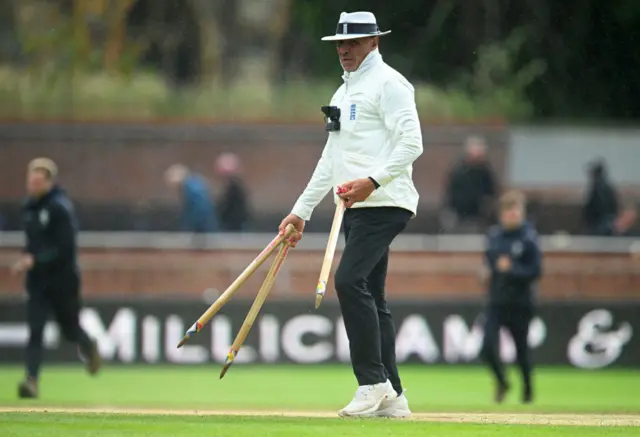 Match Umpire David Millns removes the stumps