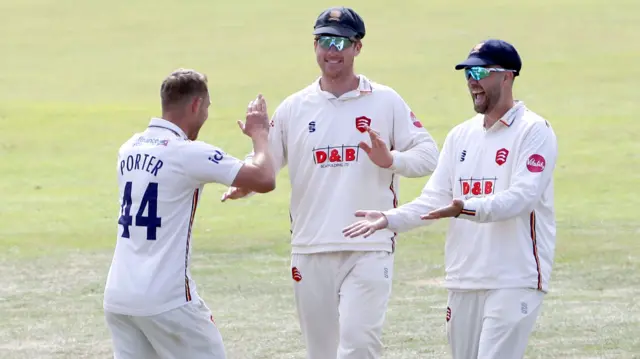 Jamie Porter of Essex celebrates with his team mates after taking the wicket of Liam Patterson-White