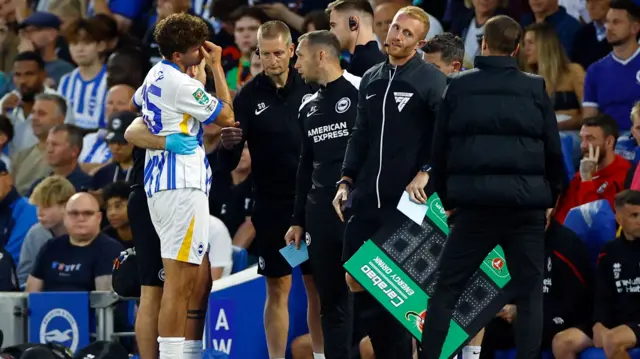 Matt O'Riley hobbles off after suffering an injury while playing for Brighton