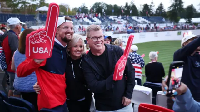 Three US fans with giant foam hands