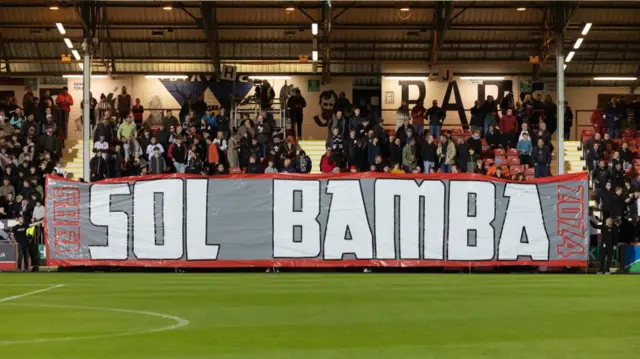 DUNFERMLINE, SCOTLAND - SEPTEMBER 13: A banner honouring former Dunfermline player Sol Bamba following his passing during a William Hill Championship match between Dunfermline and Raith Rovers at KDM Group East End Park, on September 13, 2024, in Dunfermline, Scotland. (Photo by Mark Scates / SNS Group)