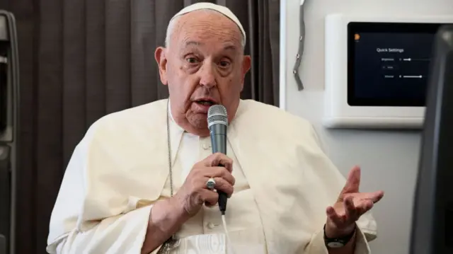 Pope Francis speaks aboard the papal plane on Friday