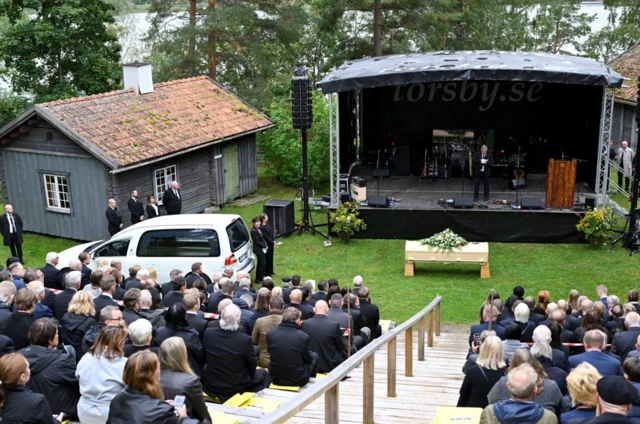 Mourners gathered on a wooden amphitheatre to hear tributes