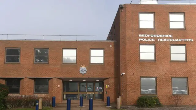 The front entrance of the three-storey Bedfordshire Police headquarters at Kempston near Bedford - a red brick building