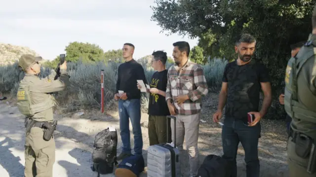 Border Patrol officer with detained migrants.