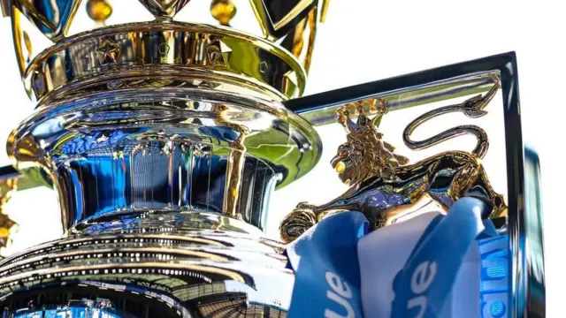 The Premier League trophy with Manchester City ribbons