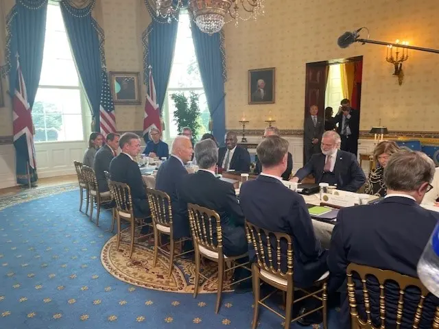 President Biden, Prime Minister Starmer, and others holding talks at a long table in the White House