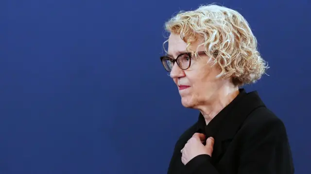 Chairwoman Lady Justice Thirlwall stands in front of a dark blue backdrop while wearing black