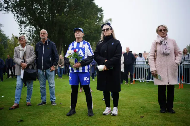 A person wearing a IFK Goteborg football kit pays respects outside the funeral service of Sven-Goran Eriksson