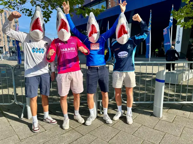 Sussex Sharks fans pose wearing shark head masks