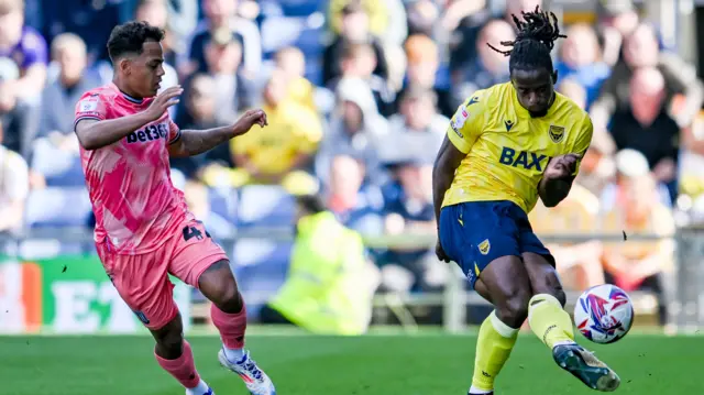 Oxford's Greg Leigh passes the ball under pressure from a Stoke player