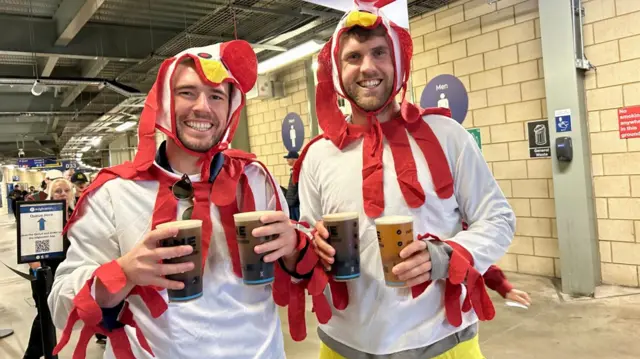 Two people dressed as chickens