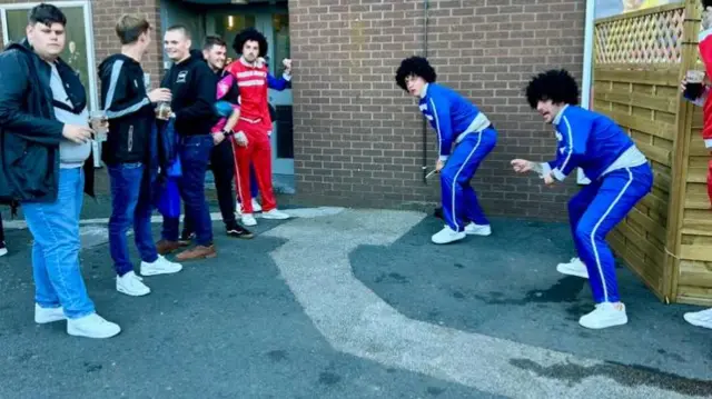 Fans playing cricket outside the ground