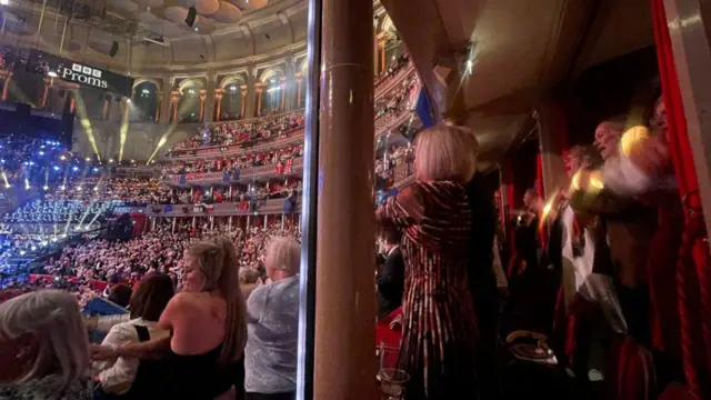 The audience crosses arms during Auld Lang Syne