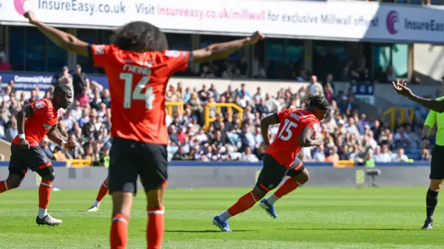 Teden Mengi runs in celebration after scoring as his team-mate holds his arms in the air