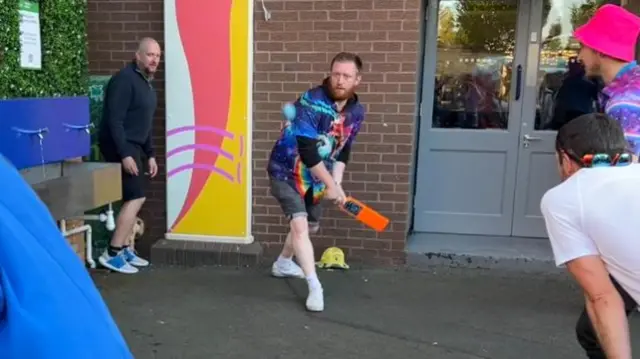 Fans playing cricket outside the ground