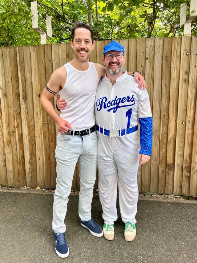 A man dressed as Freddie Mercury next to a man dressed as a baseball player