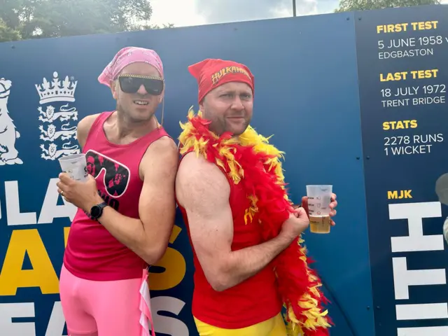 Two people dressed as wrestlers pose for a picture