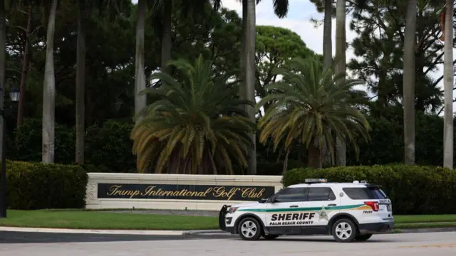 A police vehicle is seen at the entrance of the golf club