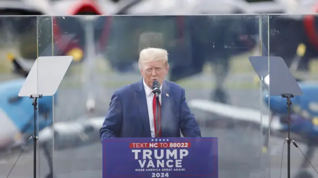 Donald Trump behind bulletproof glass