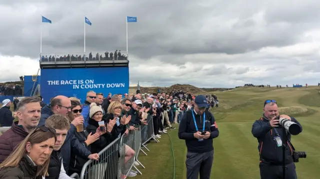 Fans line the first fairway