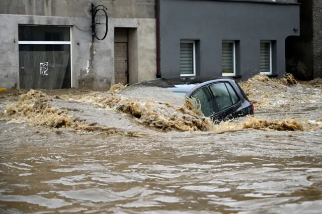 A car is submerged in water in a flooded street in Glucholazy, southern Poland