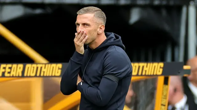 Gary O'Neil holds his right hand to his mouth as he stands in front of the dugout at Molineux.