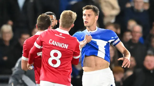 Birmingham City's Krystian Bielik fronts up to Paul Mullin with the Wrexham striker grabbing his shirt.