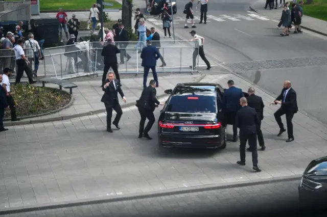 Security officers move Slovak PM Robert Fico in a car after a shooting incident