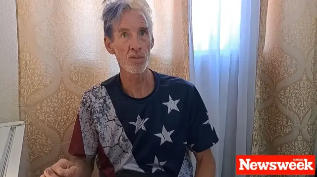 Ryan Wesley Routh during an interview with Newsweek wearing a shirt with the American flag on it