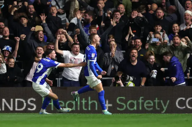 Birmingham City fans scream with joy inside St Andrew's as Jay Stansfield celebrates in front of them.