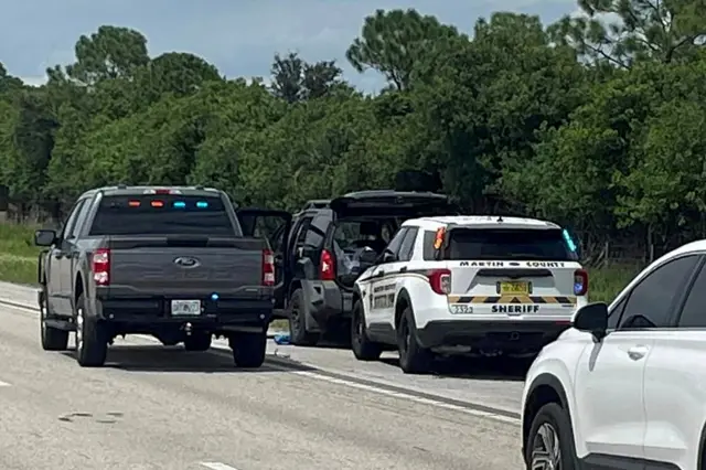 Police vehicles stop a car