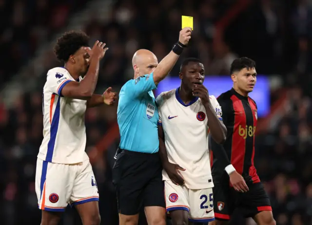 Anthony Taylor brandishes a yellow card