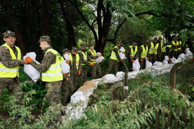 Soldiers prepare sandbags to build a barrier against flooding in Poland