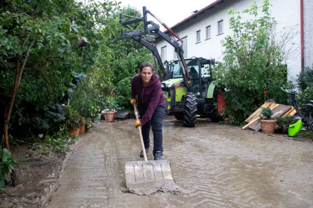 A resident cleans the pavement from mud after flooding in Grabensee, Tullnerfeld, Lower Austria, Austria on September 17, 2024