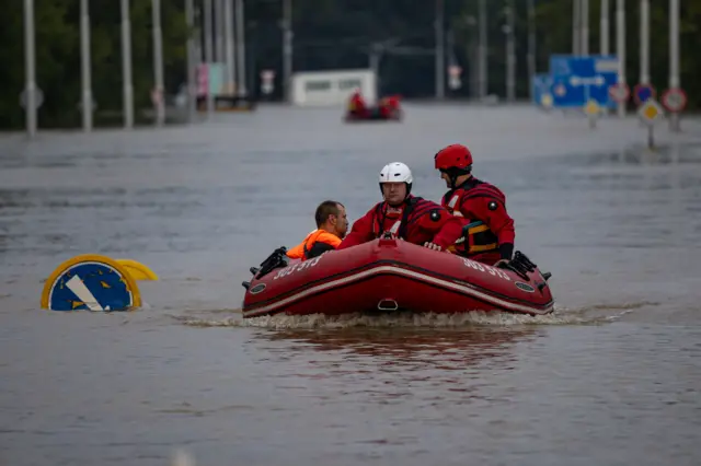 Rescuers evacuate flood-affected a resident in a boat in a flooded street following heavy rain in the town of Ostrava, Czech Republic